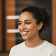 Portrait of a smiling woman in her late 20s, exuding confidence and happiness.